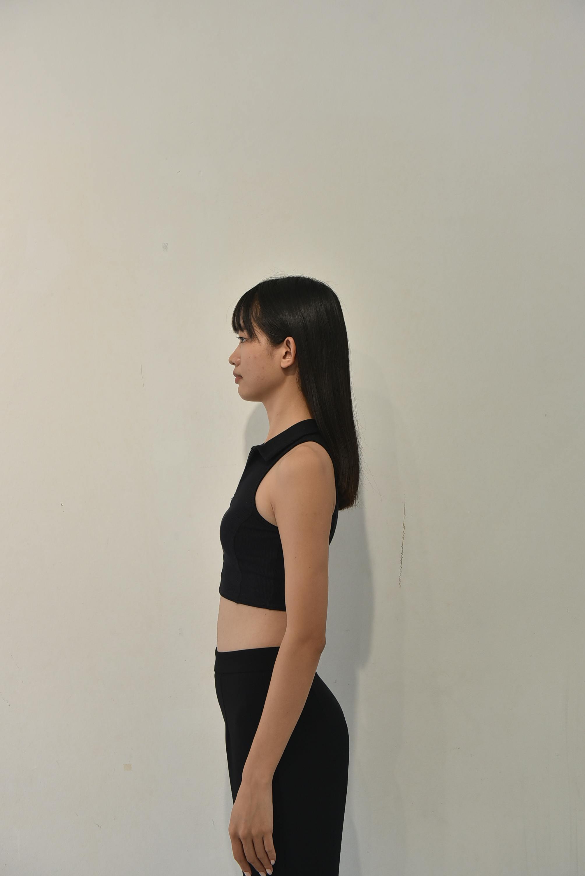 Profile portrait of a woman in a black top against a neutral background.