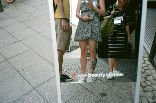 Reflection Photo of People Standing Near a Mirror