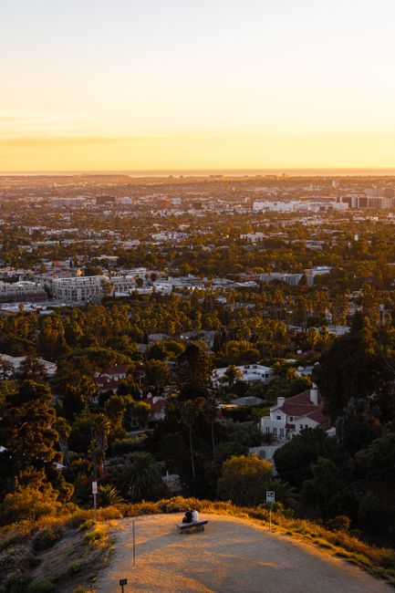 Breathtaking sunset over Los Angeles with sprawling cityscape and lush greenery.