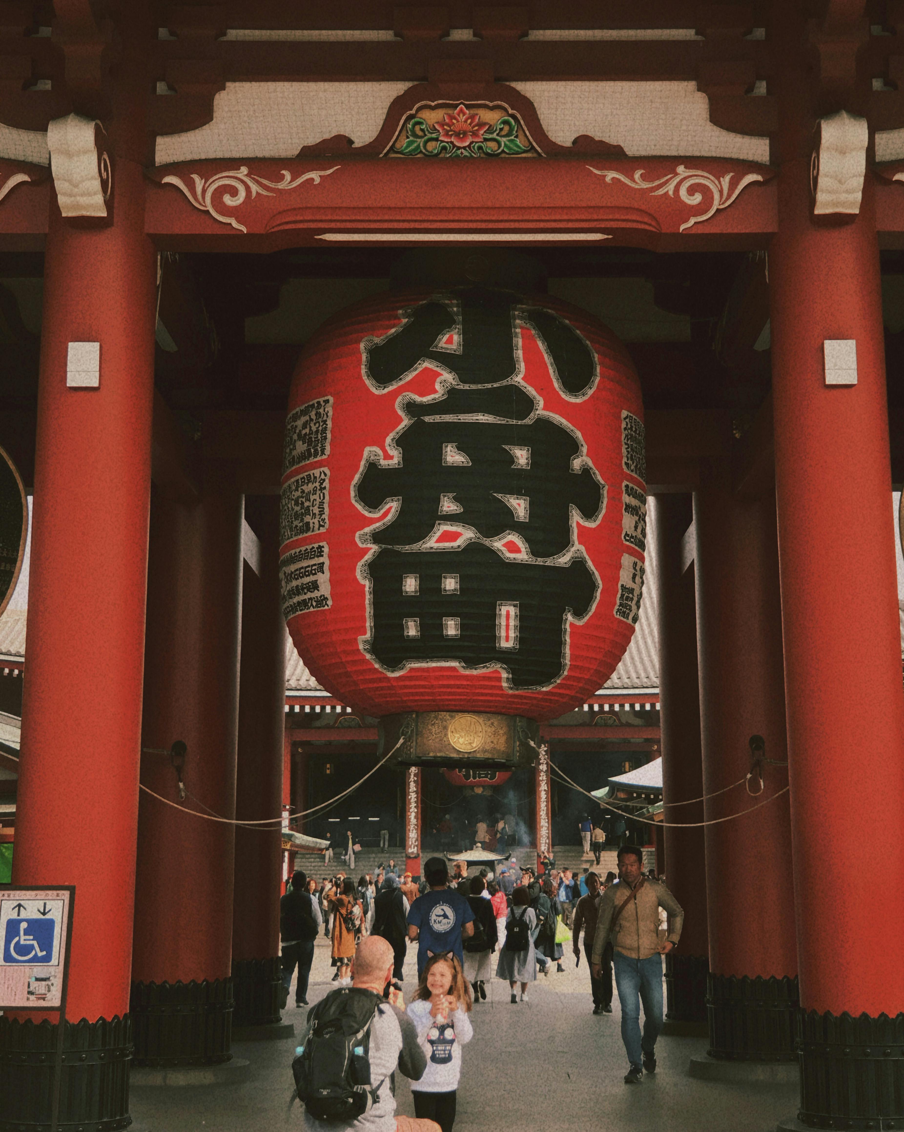 Visitors walking through the iconic entrance of Senso-ji Temple in Tokyo, Japan.