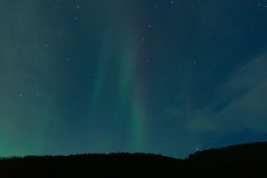 Capture of northern lights dancing over Tromsø's night sky, showcasing nature's grandeur.