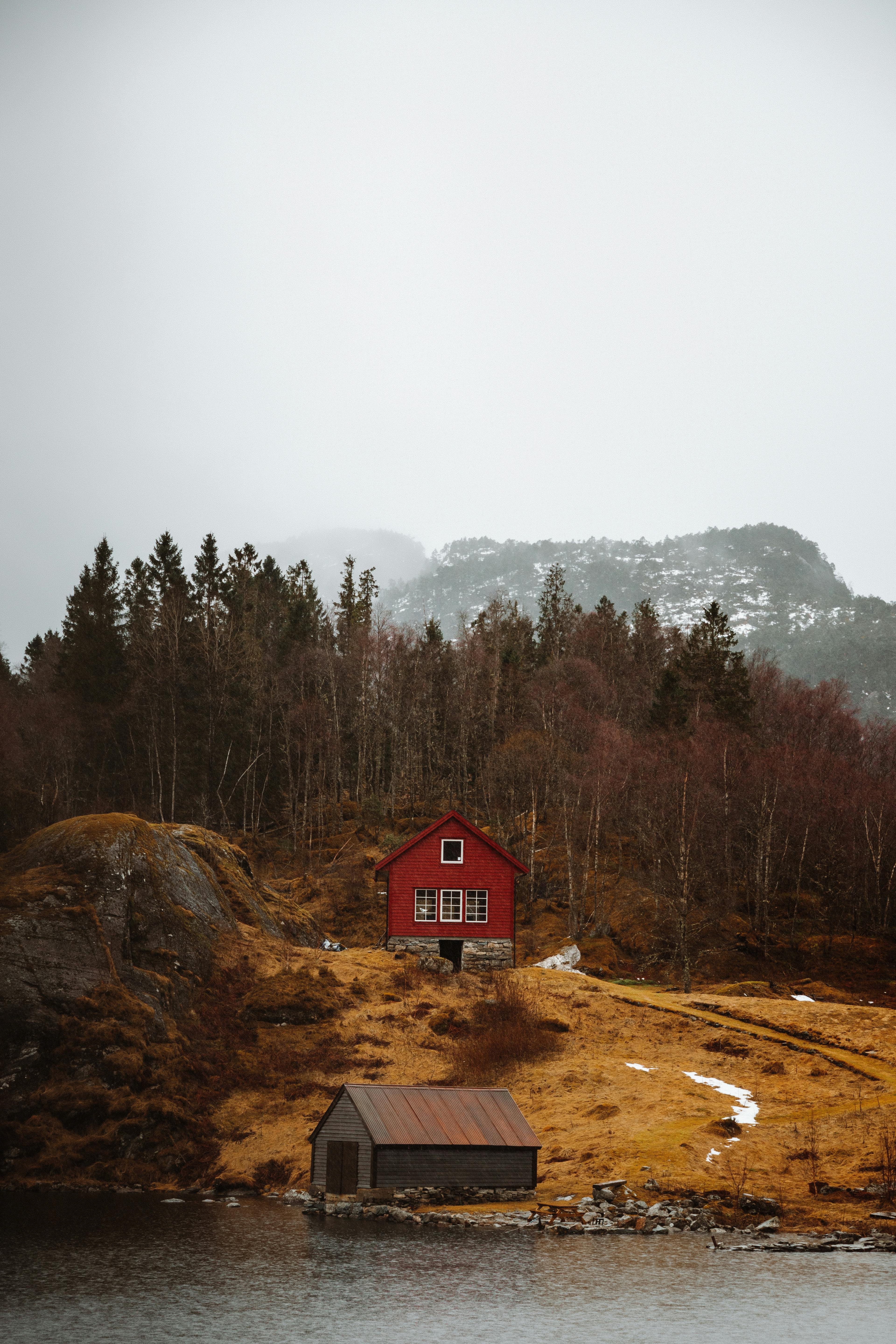 A picturesque red cabin in a tranquil Norwegian landscape near Bergen.