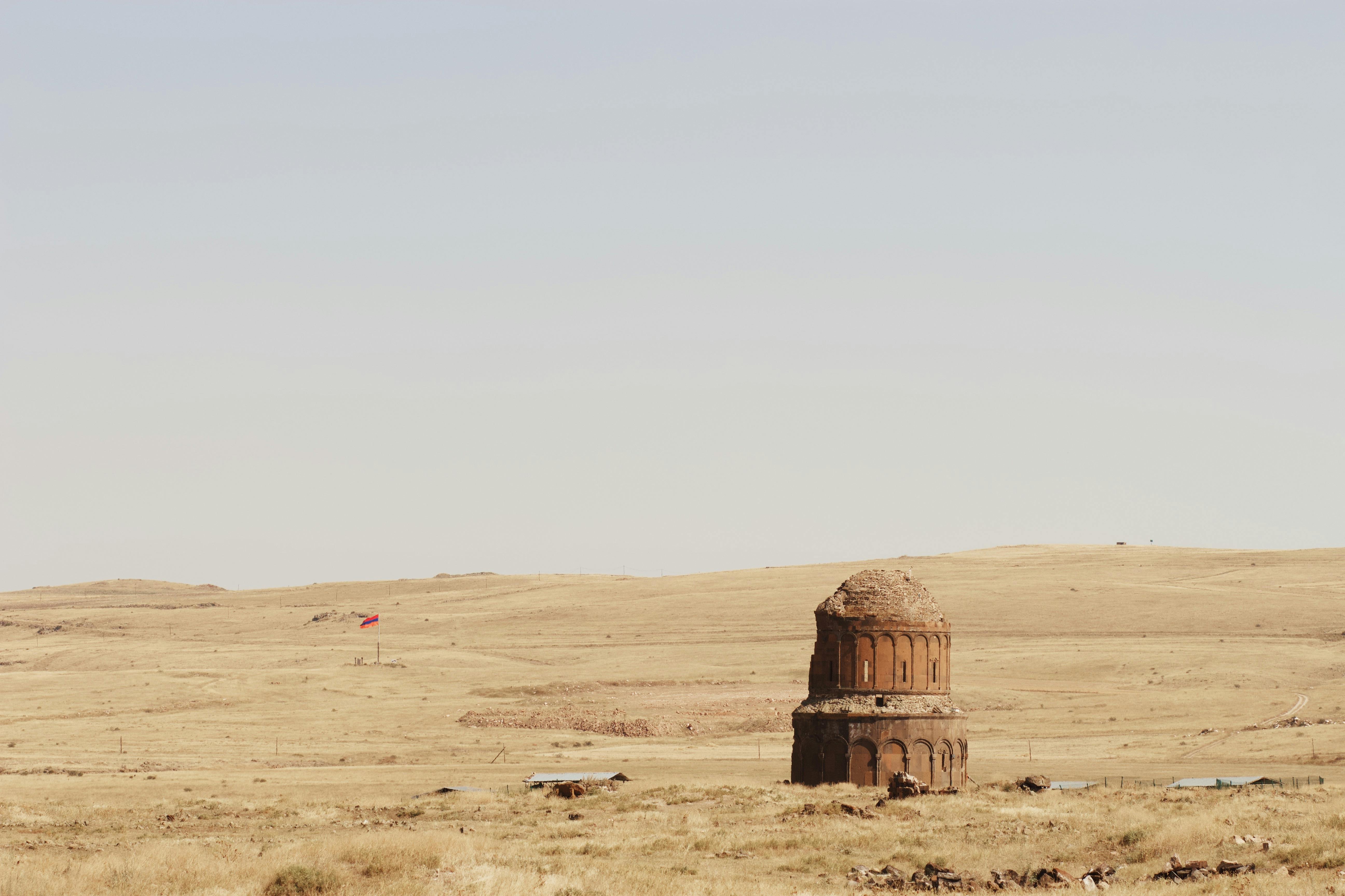 Ancient stone structure in a vast Turkish landscape, under a clear sky.