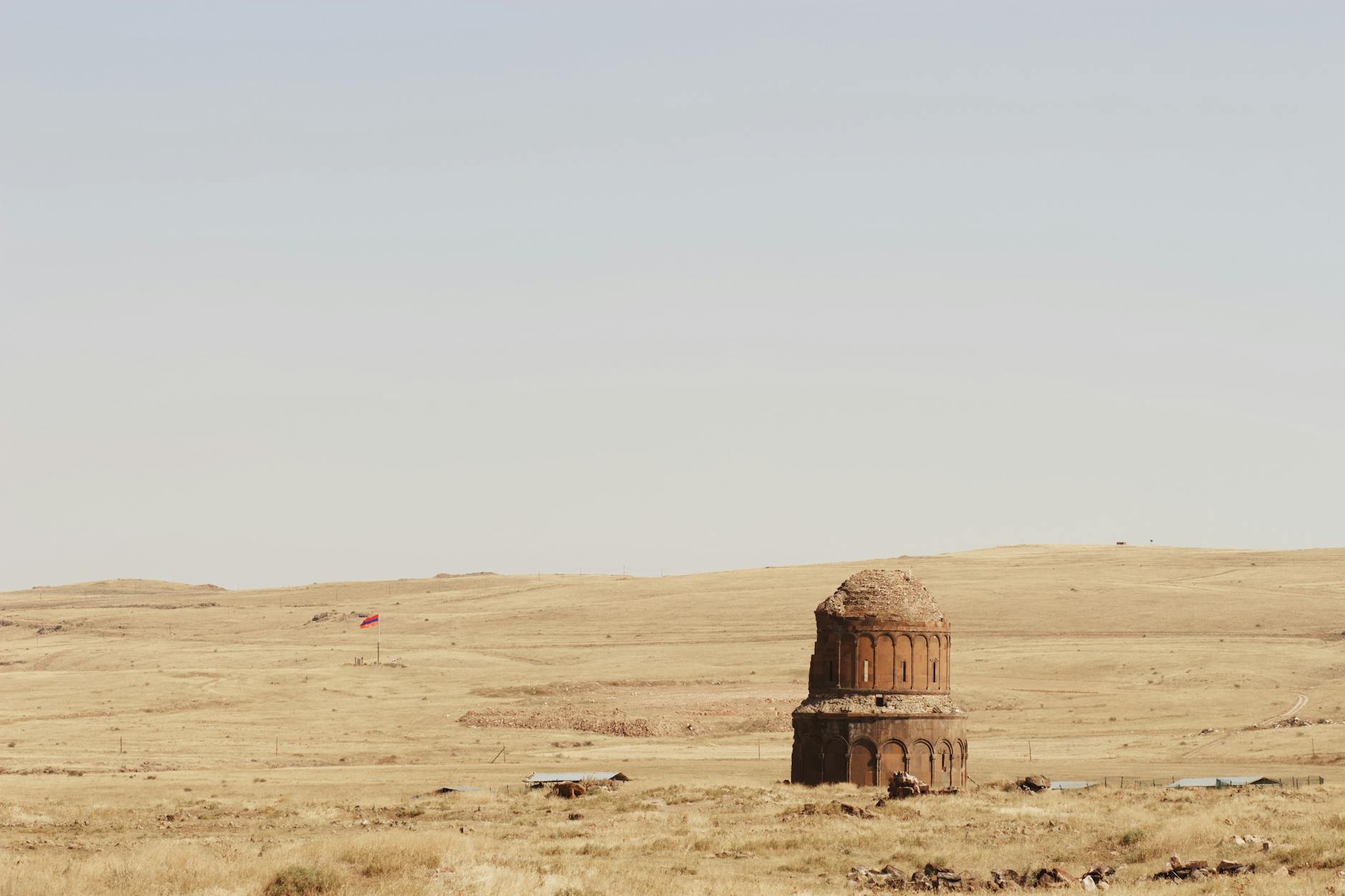 Ancient stone structure in a vast Turkish landscape, under a clear sky.