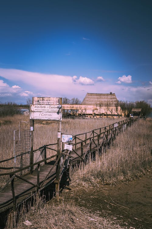 Rustic Wooden Pathway to Traditional Thatched Building · Free Stock Photo