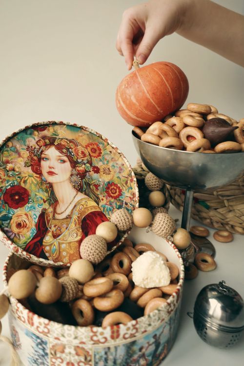 Free Artistic arrangement of donuts with a vintage portrait and small pumpkin, creating a warm still life scene. Stock Photo
