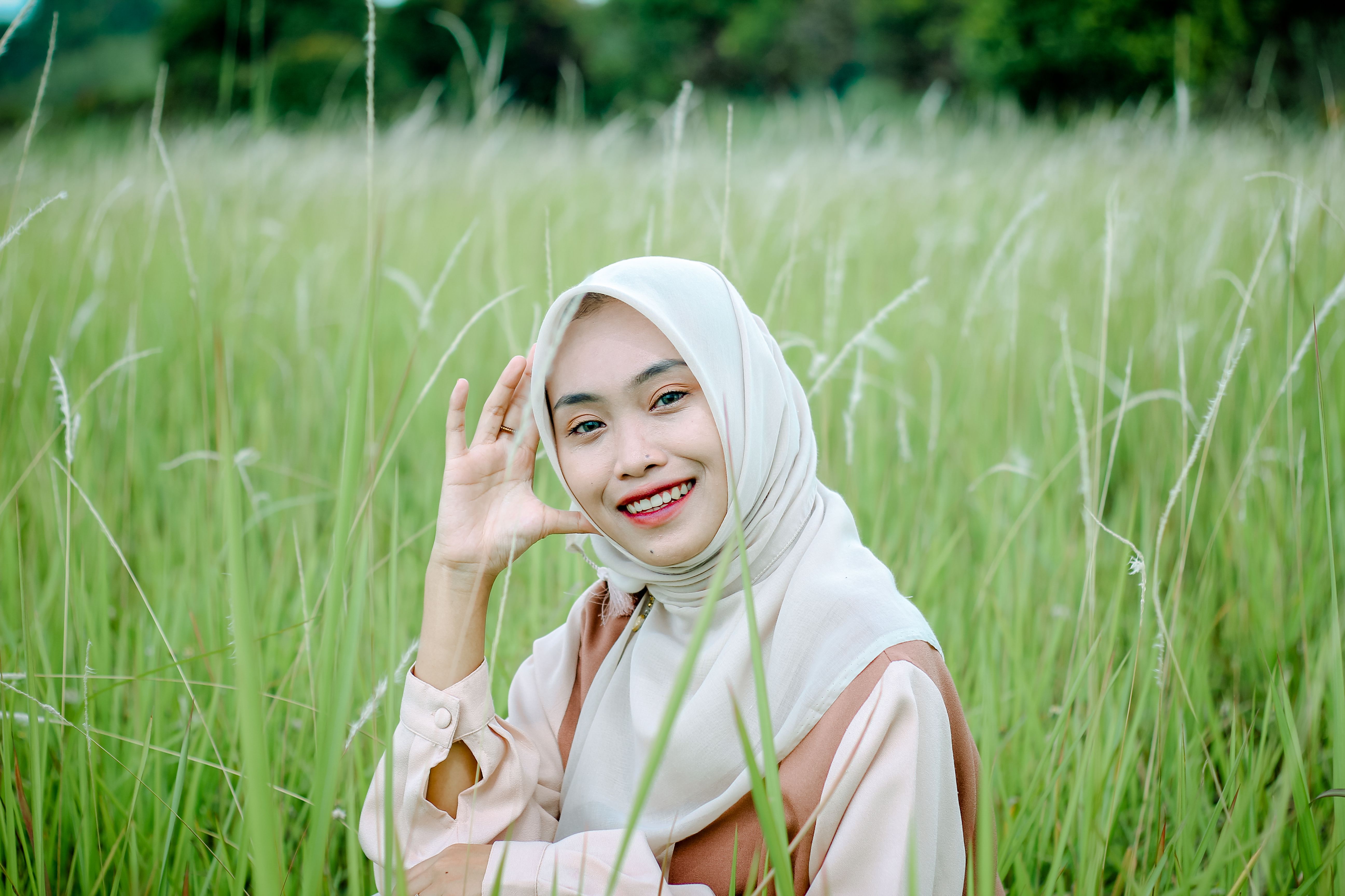 Young Woman in Hijab Smiling in Green Field · Free Stock Photo