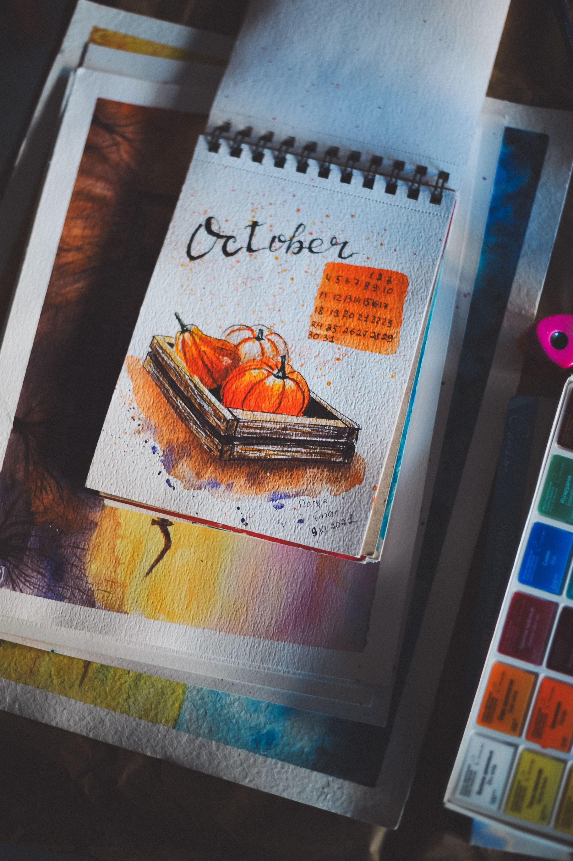 Watercolor illustration of pumpkins in a sketchbook, capturing the essence of October with vibrant colors.