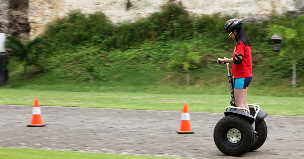 Segway Ridng Young Girl Riding Segway Outdoors with Safety Gear · Free Stock Photo