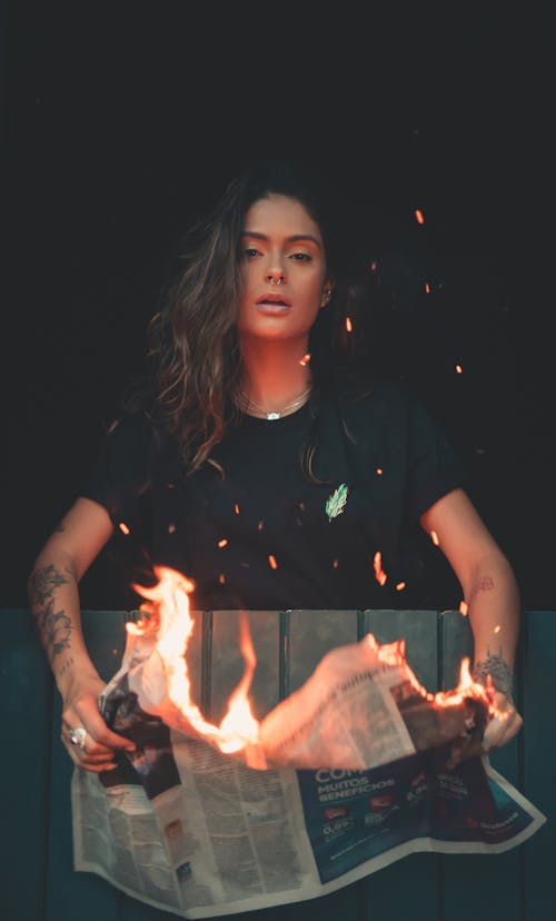 Woman Holding Burning Newspaper