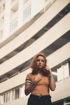 一名年轻女子表情严肃，对着现代城市建筑摆姿势