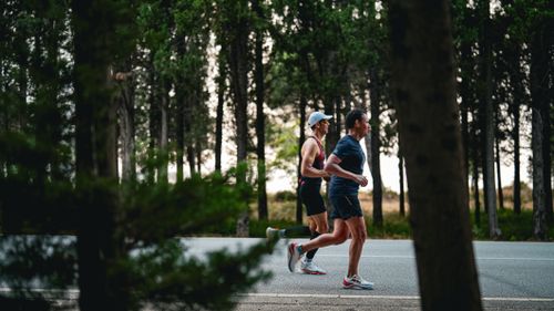 Free Two adults jogging on a forest road in Gelibolu, Türkiye. Stock Photo