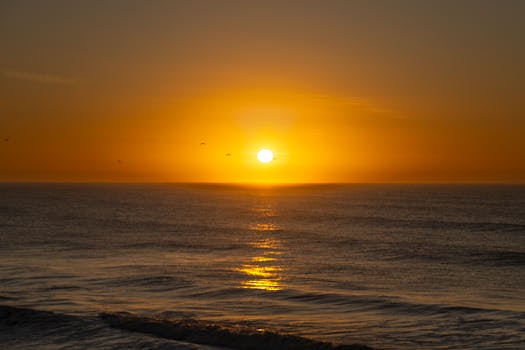 Breathtaking sunrise over the Atlantic Ocean at Mar del Plata, Argentina. Calm waves and vibrant colors.