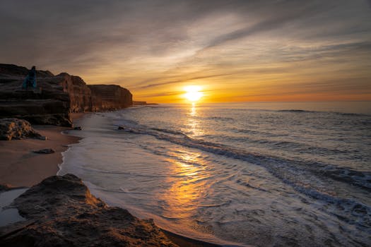 Capture the serene beauty of a golden sunrise over Mar del Plata beach in Argentina.