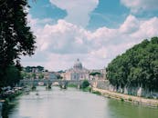 从罗马台伯河对岸望去，圣彼得大教堂绿树成荫