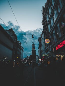 Explore the lively streets of Amsterdam at night, showcasing urban architecture and vibrant city life.