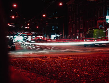 Long exposure of vibrant city traffic lights streaking across Amsterdam street at night.