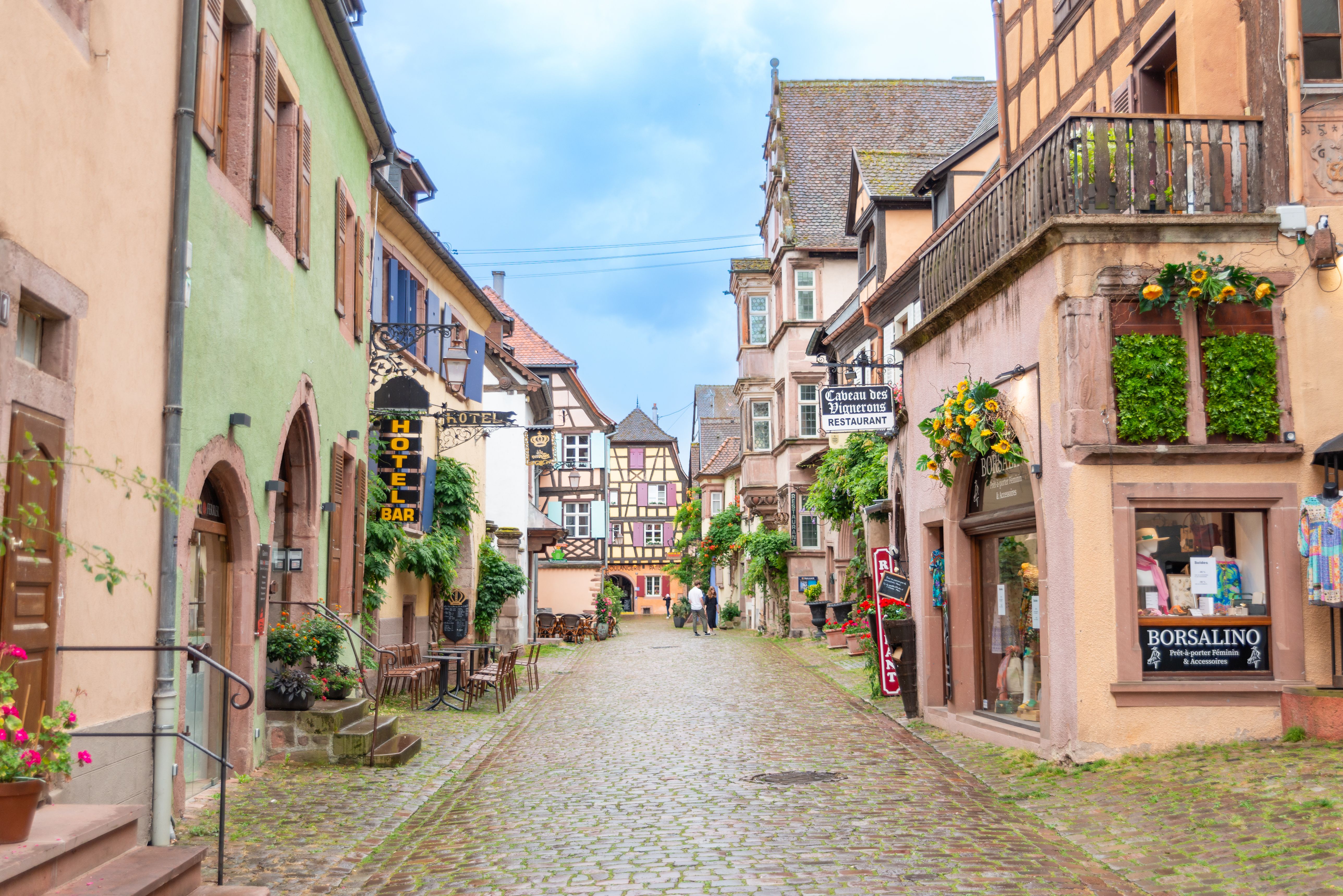 Picturesque street in an Alsace village showcasing traditional architecture and cobblestone path.