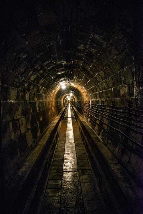 Free A moody, dimly lit underground tunnel with a vanishing point. Stock Photo