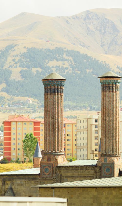 Free Historical minarets in front of mountains and colorful buildings. Stock Photo