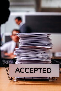 在繁忙的办公室环境中，一堆贴有“已接受”标签的文件凸显了信息管理的重要性