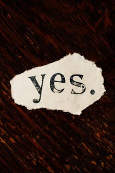 在纹理木质背景下，一张质朴的撕破纸上显示着“是”一词