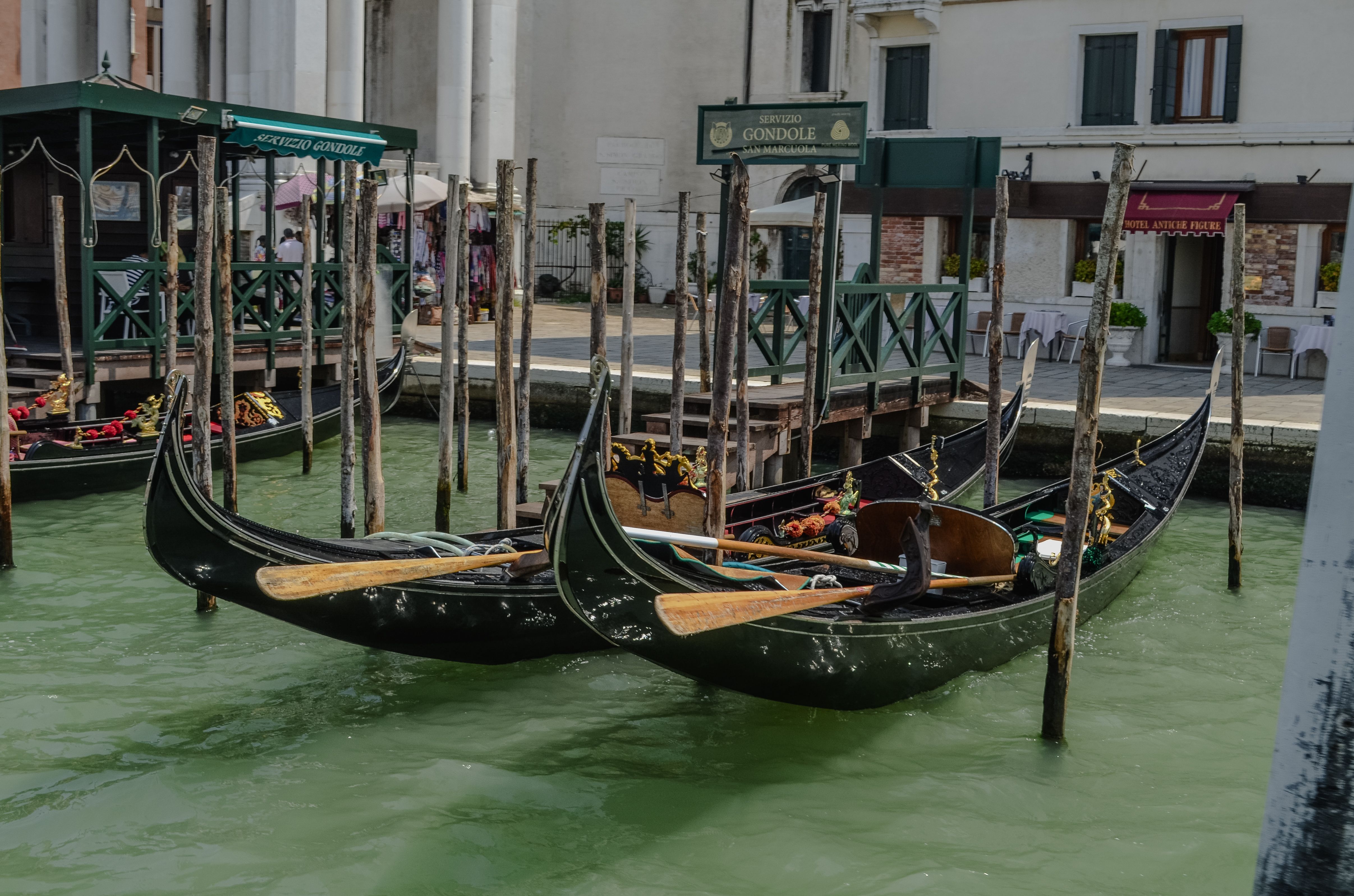 Gondolas moored at a dock in the picturesque canals of Venice, Italy.