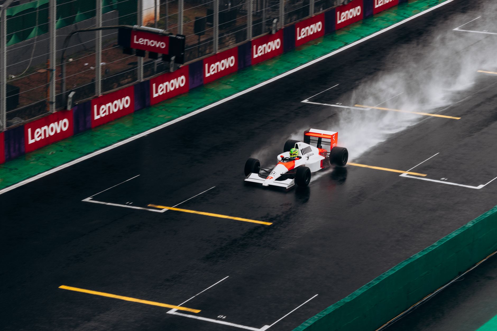 Formula 1 car racing on a wet track with spray, creating dynamic motion and excitement.