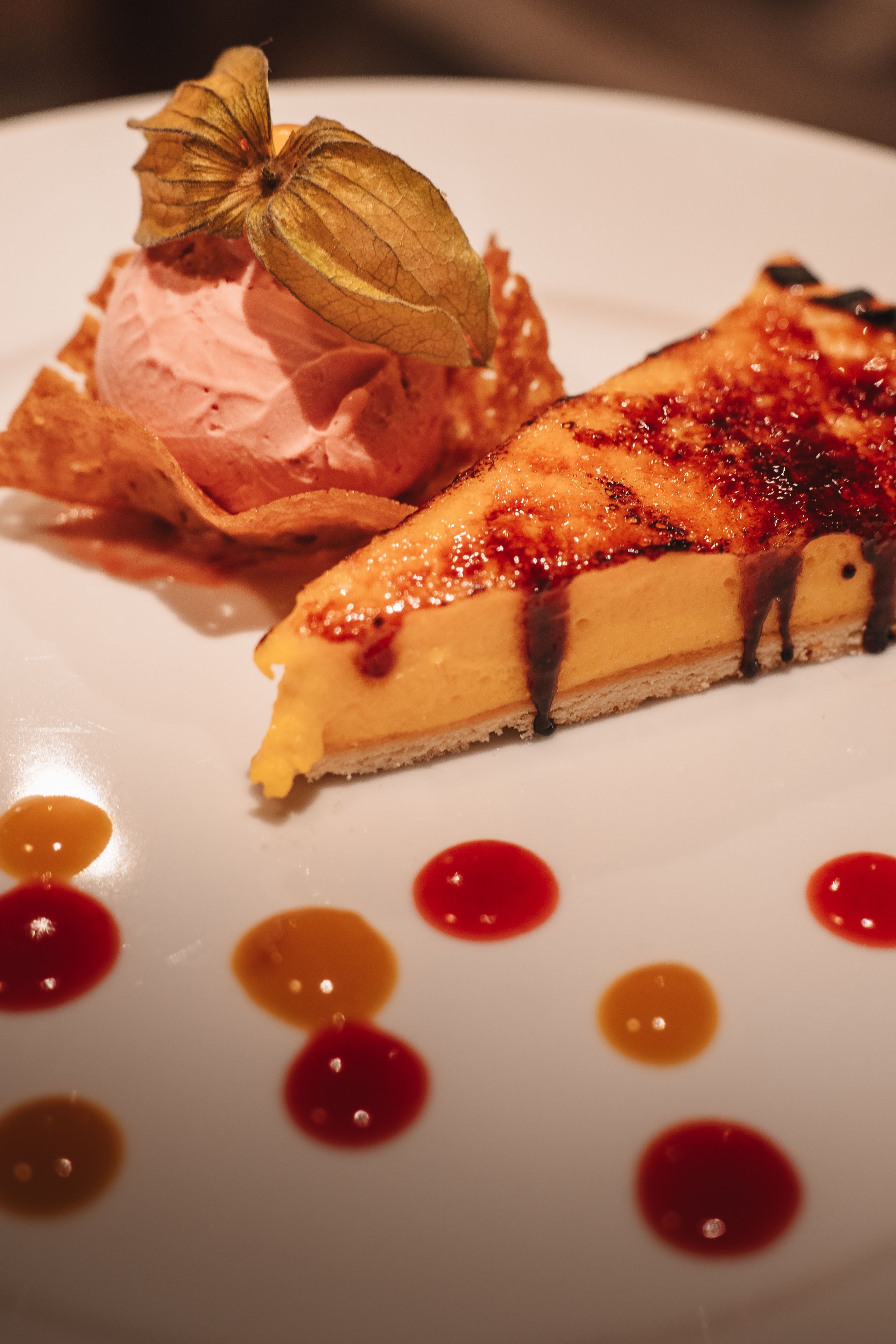 A baking dish of pastel de choclo with a golden, slightly caramelized corn topping and a spoon lifting out a portion revealing the meat, egg, and olive filling underneath.