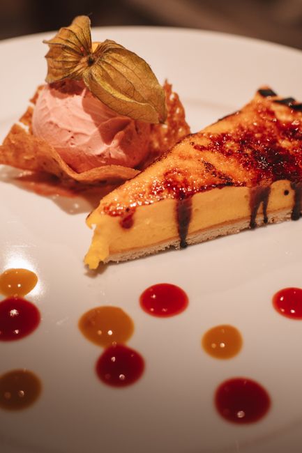 A baking dish of pastel de choclo with a golden, slightly caramelized corn topping and a spoon lifting out a portion revealing the meat, egg, and olive filling underneath.