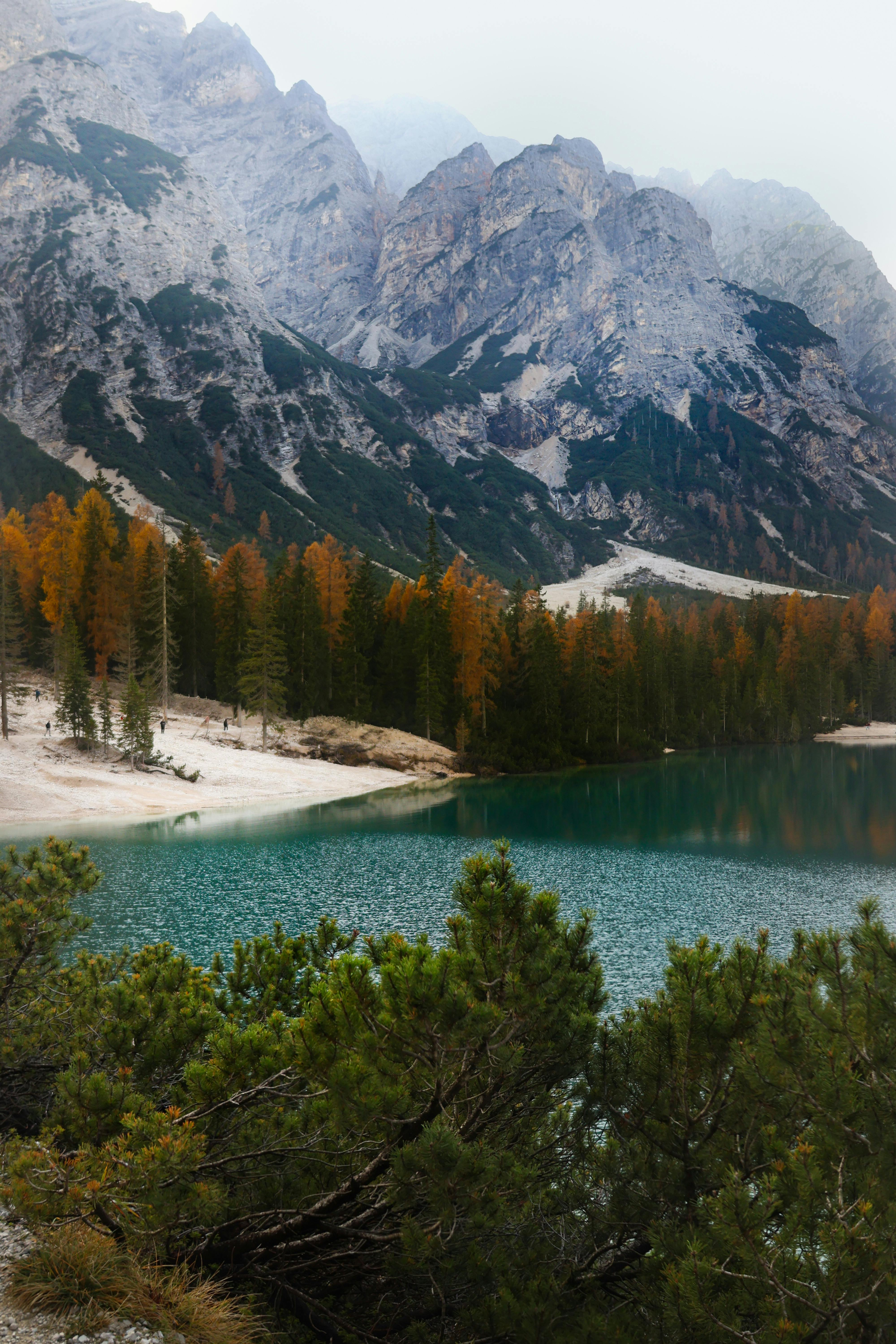Serene alpine lake surrounded by the majestic Dolomite mountains in fall, Italy.
