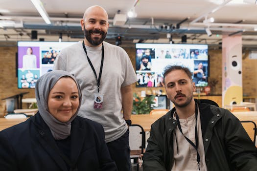 Three colleagues working together in a modern office setting, smiling and interacting.
