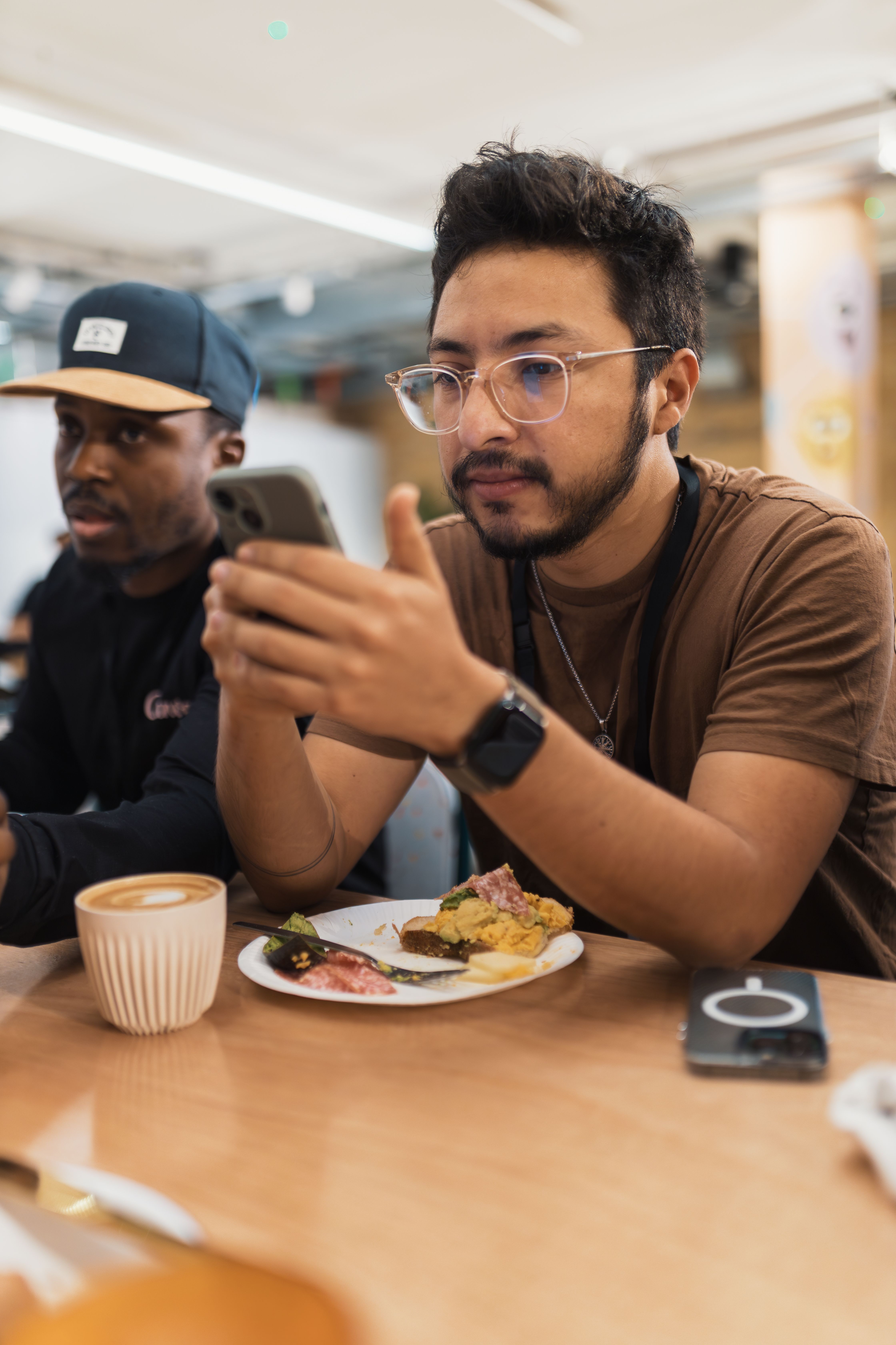 Tech-Savvy Young Adult Dining in a Café · Free Stock Photo