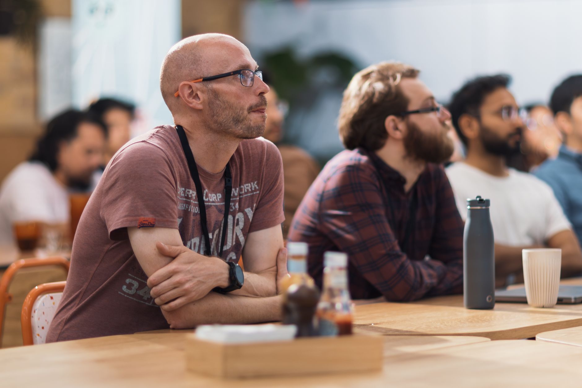 A diverse group of adults attentively engaged in a conference setting indoors.