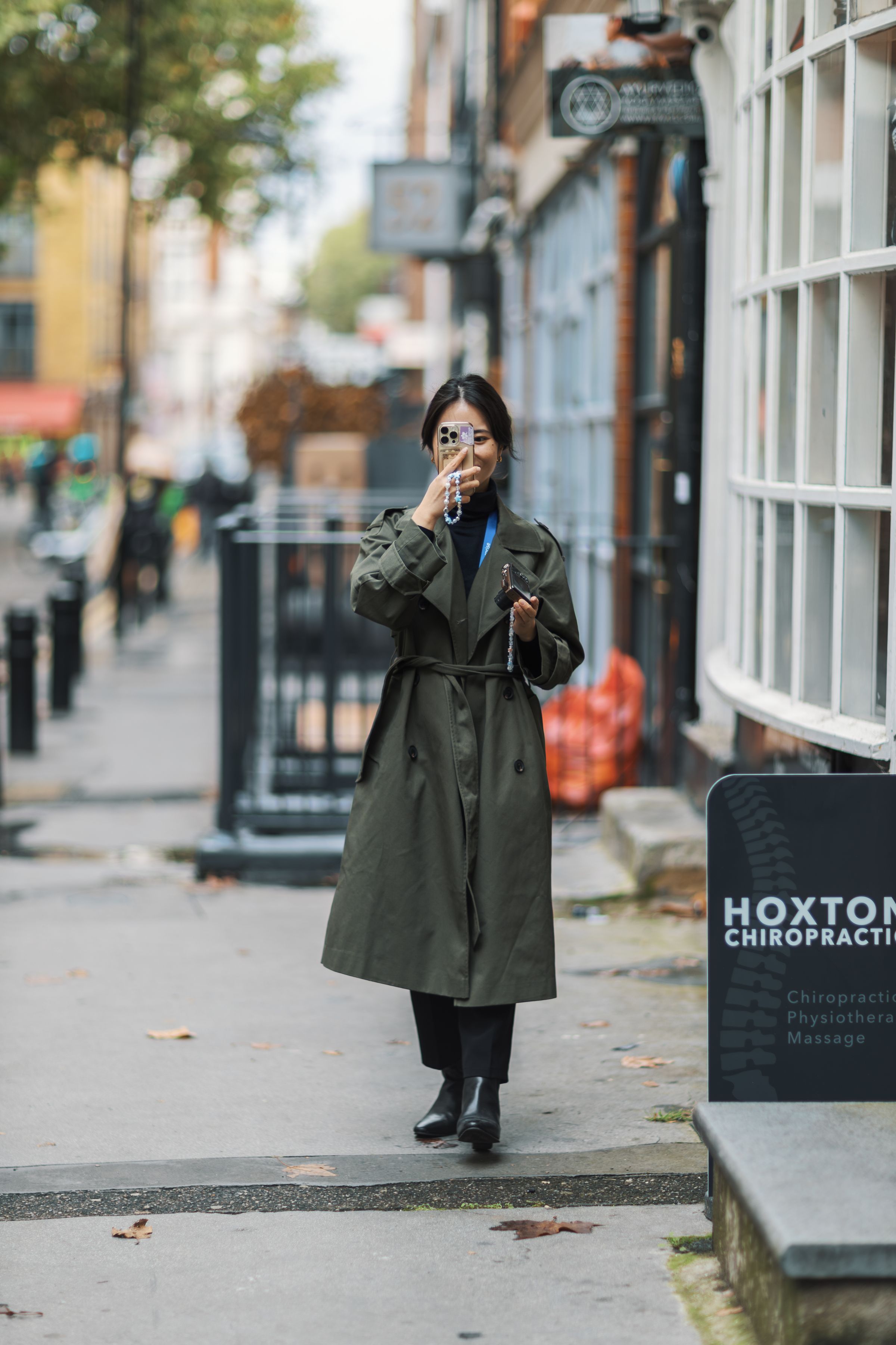 People walking down a rainy London street with umbrellas in autumn