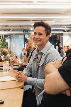 Smiling professionals engaged in a collaborative team meeting at a modern office workspace.