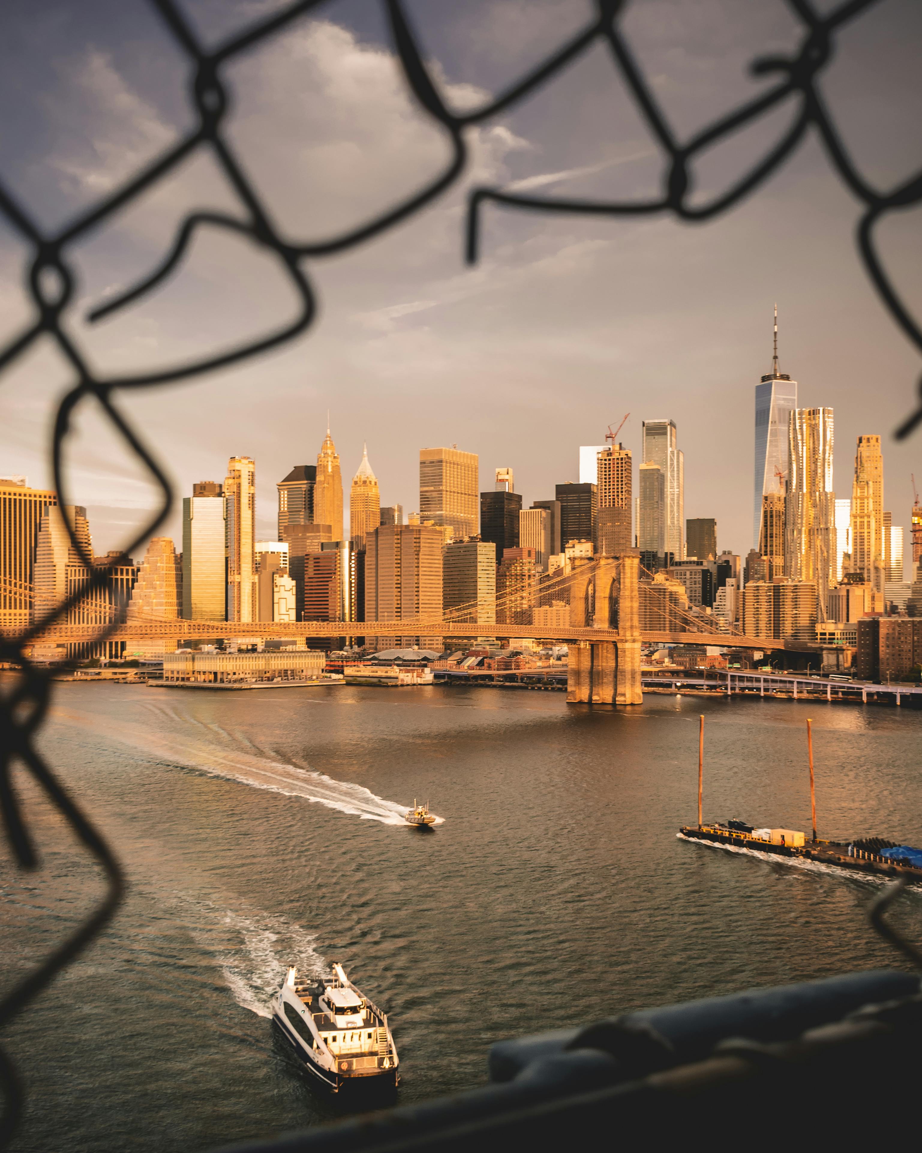 黄昏时分，在河上乘坐渡轮可欣赏纽约市天际线和布鲁克林大桥的美丽景色