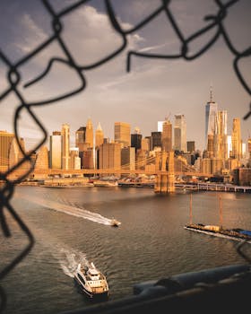 黄昏时分，在河上乘坐渡轮可欣赏纽约市天际线和布鲁克林大桥的美丽景色