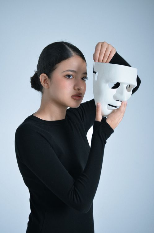 Woman Holding White Mask in Reflective Pose · Free Stock Photo