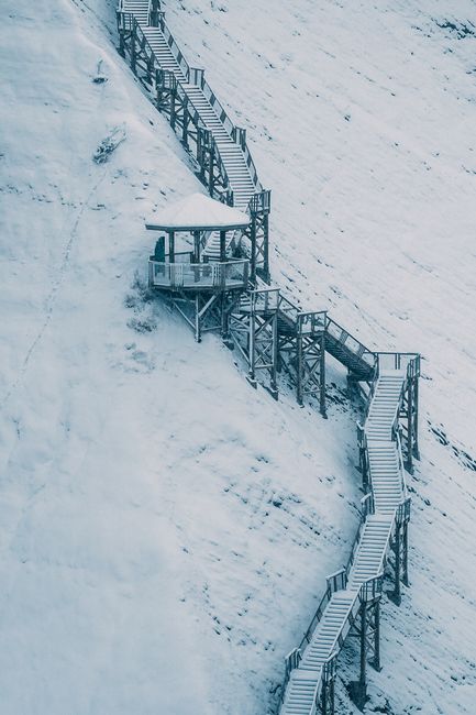 A long stairway covered with snow, winding through a winter landscape in Québec, Canada.