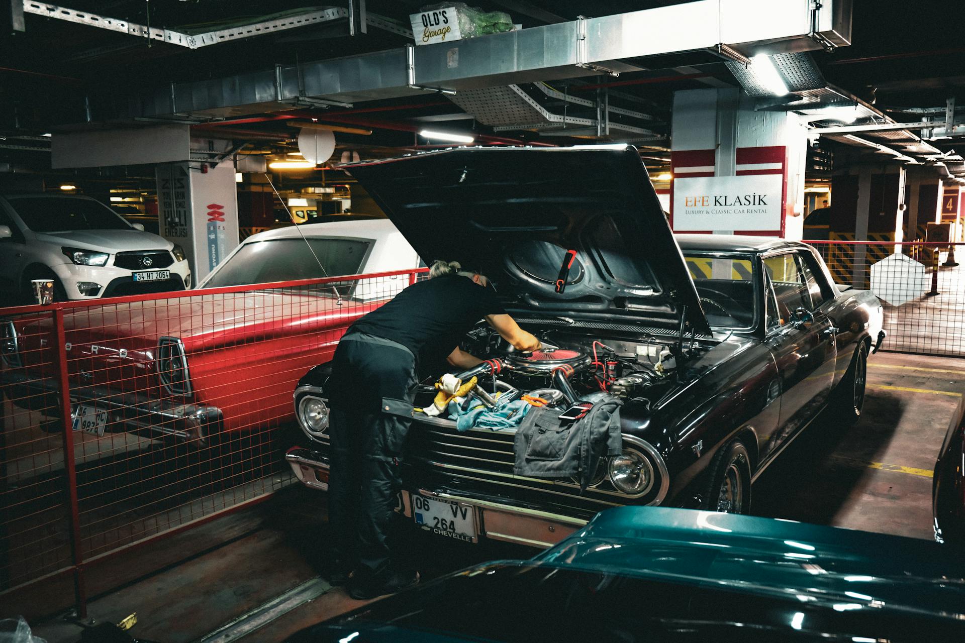 Mechanic repairing a classic car engine in an underground garage in Ankara, Türkiye.