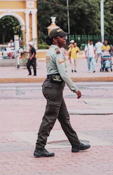 A Colombian policewoman patrolling a busy city square with people in the background.