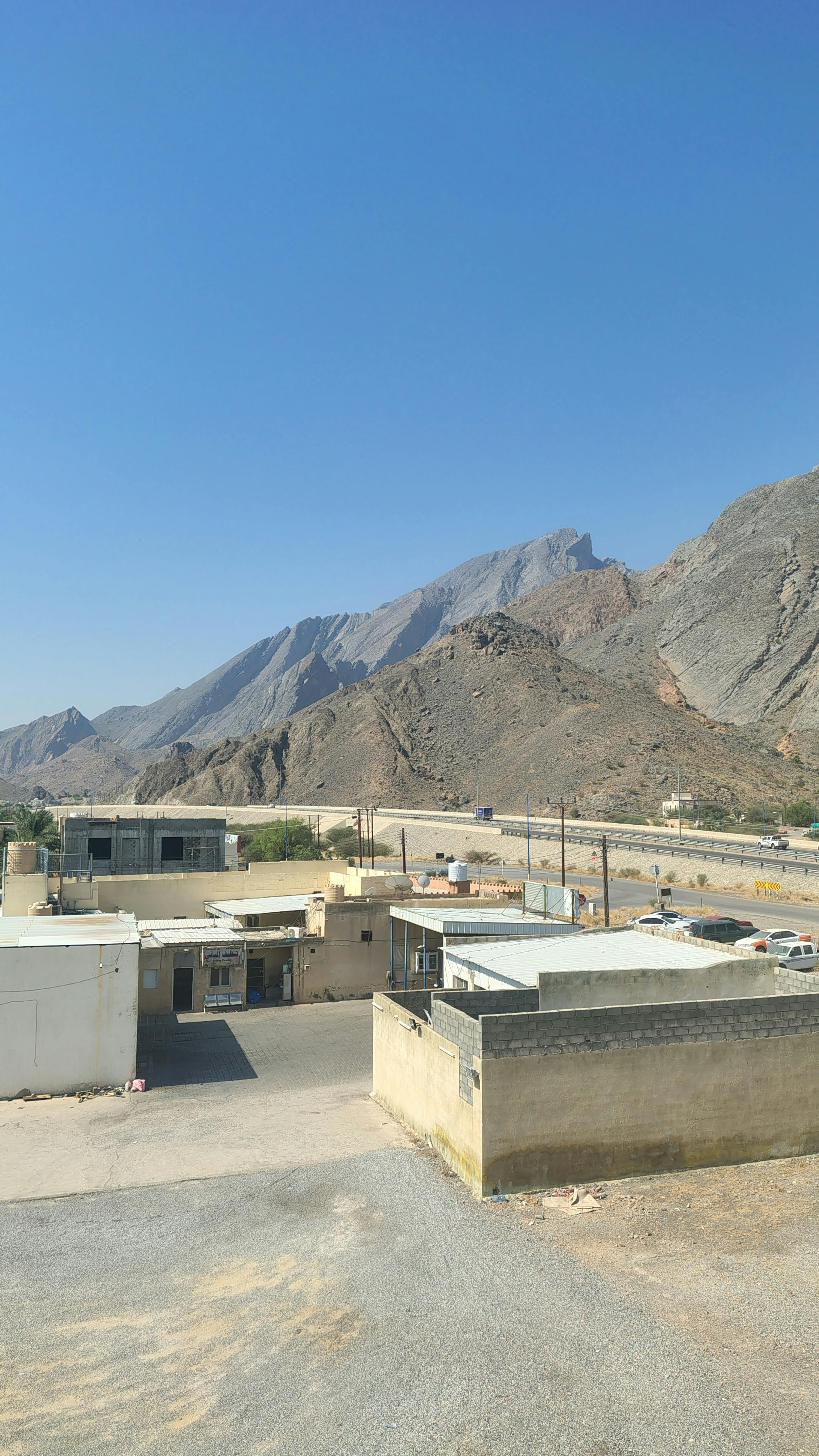 A serene mountain village under a bright blue sky, showcasing rustic architecture and vast landscapes.