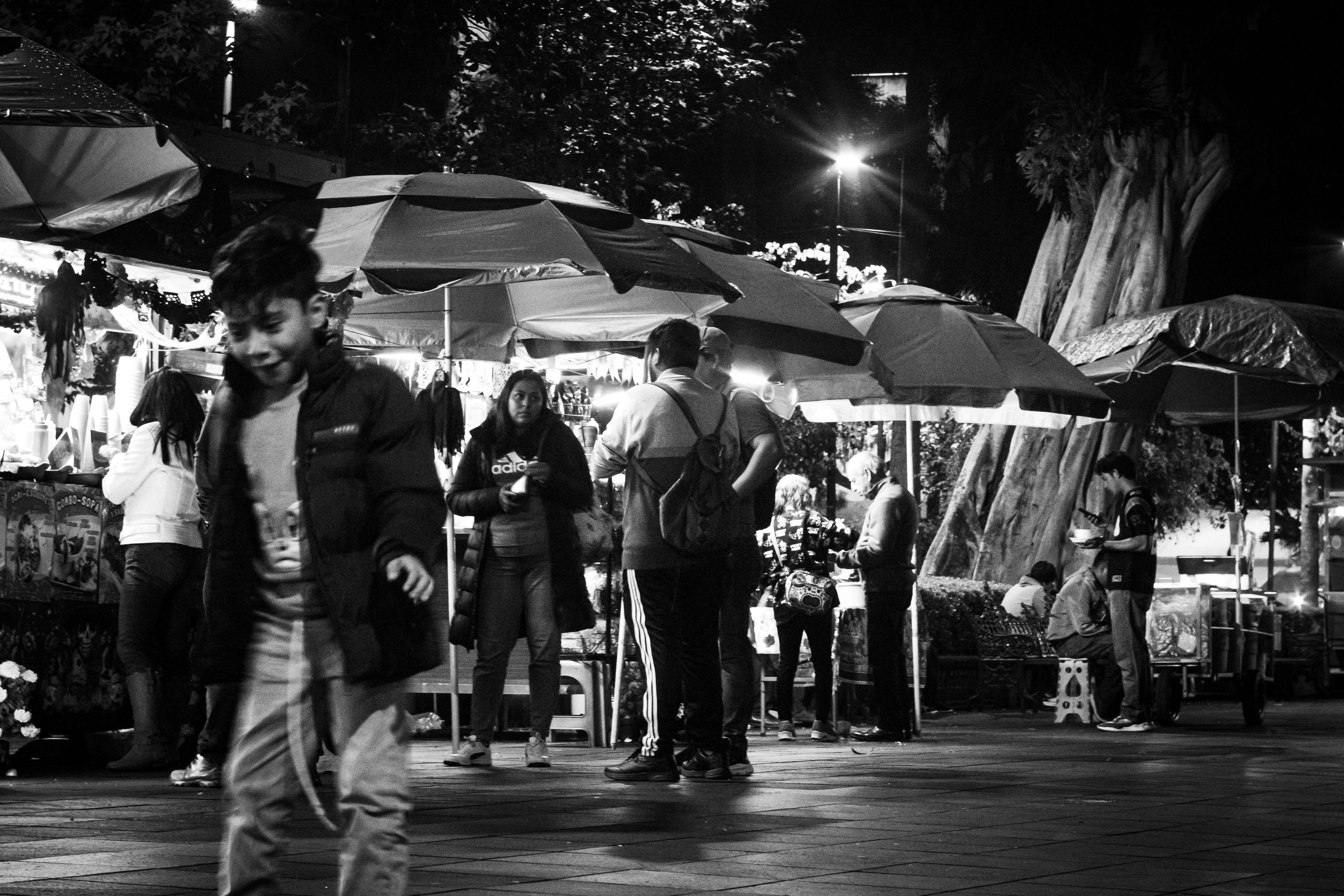 Escena en blanco y negro de un bullicioso mercado nocturno en Xalapa, México.