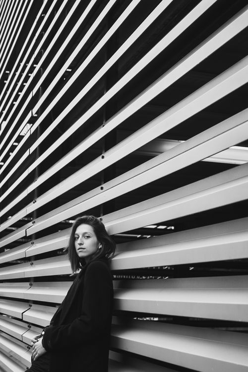 Free Stylish black and white portrait of a woman posing against modern architecture. Stock Photo
