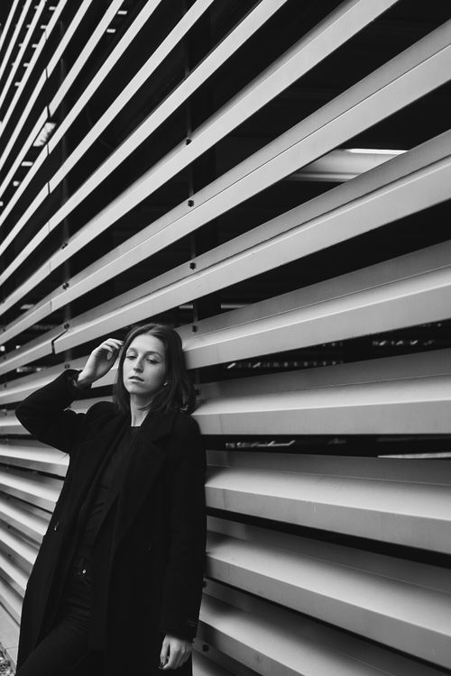 Free Artistic black and white portrait of a woman posing against an industrial background. Stock Photo