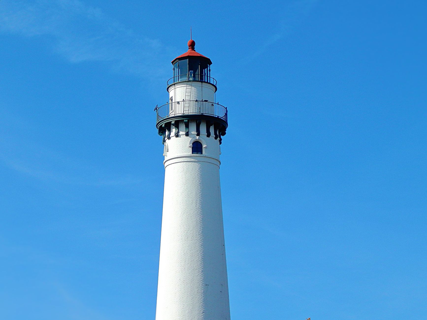 View of Wind Point Lighthouse in front of a clear blue sky in Wisconsin.