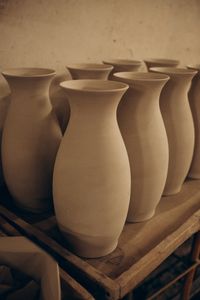 Unglazed ceramic vases drying on a workshop shelf — photo by Irina Novikova on Pexels
