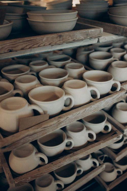 Ceramic cups on wooden shelves by Irina Novikova on Pexels