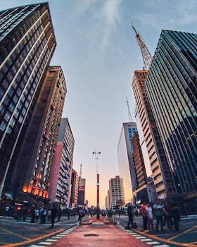 繁华城市的街景充满活力，高耸的摩天大楼映衬着鲜艳的日落天空